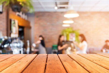 Selective focus of wooden table with blur coffee and restutant cafe with customers.