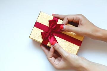female hands with beautiful manicure hold a gift box