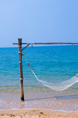 Close up of cozy hammock on the tropical beach by the sea. Peaceful seascape. Relax, travel concept, travelling.