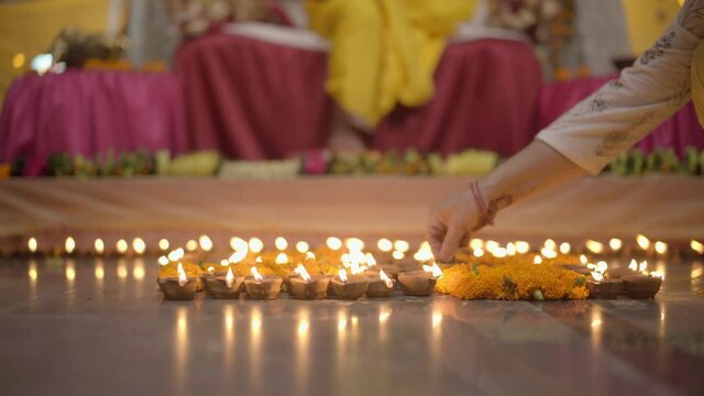 Indian Girl lighting Diyas in home temple. Happy Diwali.  Celebration Ram Mandir construction. Apple prores 422 4k