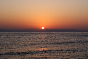 Fototapeta premium Beautiful dawn over the sea. Sunny path on the water. Light wave and swell on the surface of the water