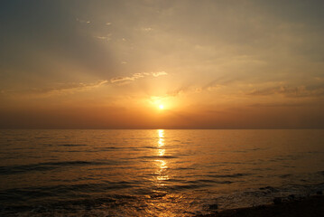 Obraz premium Beautiful dawn over the sea. Sunny path on the water. Light wave and swell on the surface of the water
