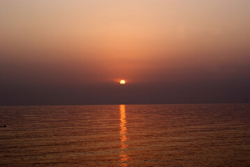 Naklejka premium Beautiful dawn over the sea. Sunny path on the water. Light wave and swell on the surface of the water