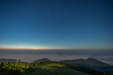Naklejka na ściany i meble The night sky in the Carpathian mountains before sunrise