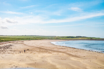 A beach at the north coast of Scotland, on a sunny day.