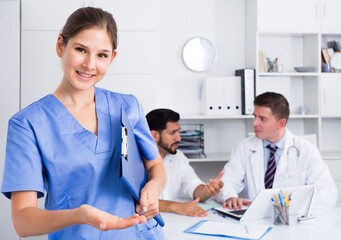 Young smiling female doctor welcoming patient to clinic