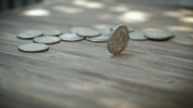 Silver Coin Rotating On A Wooden Table. Spinning American Dollars Coin.