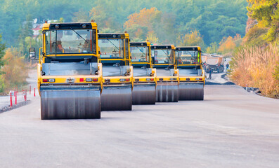 Heavy Vibration roller at asphalt pavement works (road repairing). Five road rollers working in...