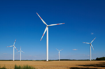 Wind energy / four wind turbines and stubble field