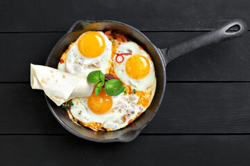 Top view of frying pan with three fried eggs