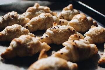 Freshly baked homemade croissants on wooden table, selective focus Fresh out of the oven. Breakfast or brunch concept.