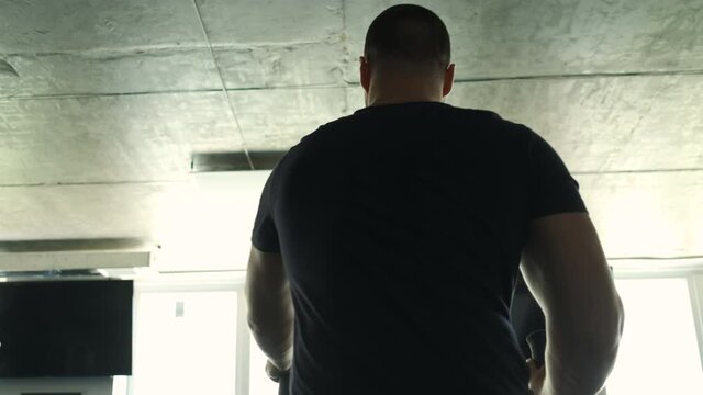 Professional athlete does cadre training on orbitrek. Preparation for competitions. Frame from the back