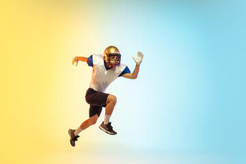 Fototapeta na wymiar High jump. American football player isolated on gradient studio background in neon light. Professional sportsman during game playing in action and motion. Concept of sport, movement, achievements.