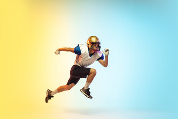 Fototapeta na wymiar High jump. American football player isolated on gradient studio background in neon light. Professional sportsman during game playing in action and motion. Concept of sport, movement, achievements.