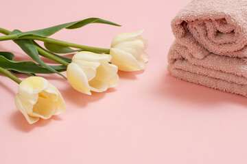 Obraz na płótnie Canvas Soft terry towels with flowers on a pink background.