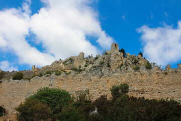 Fototapeta na wymiar View from the bottom of the three-level castle of Saint Hilarion against a blue sky with clouds. Cyprus.