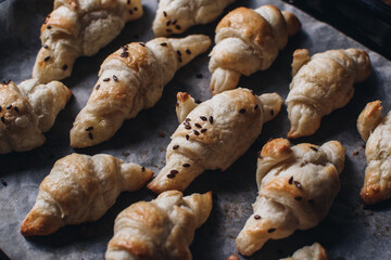 Freshly baked homemade croissants on wooden table, selective focus Fresh out of the oven. Breakfast or brunch concept.