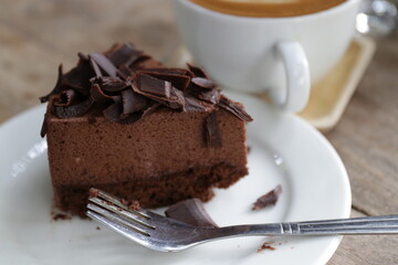 Close up Chocolate Cake , Topped with Shredded   Chocolate , a Cup of Hot Latte