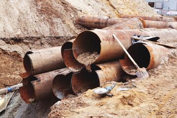 Fragments of old large water pipes. After many years of operation, corroded metal pipe destroyed....