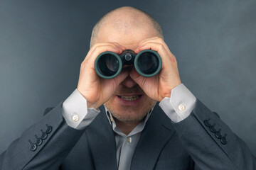 man in a business suit looks through binoculars. goals in a successful business.