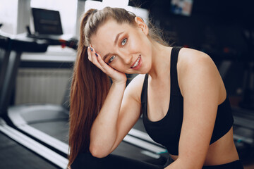 Obraz premium Brunette young woman sitting tired in a gym after workout