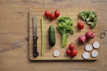 Fresh vegetables on a cutting board on a wooden table