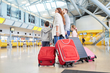 Family and children with many suitcases in the airport - obrazy, fototapety, plakaty