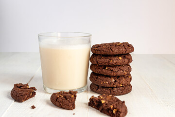 stuck of chocolate brownie cookies and glass of coconut milk on wooden background. Homemade pastry
