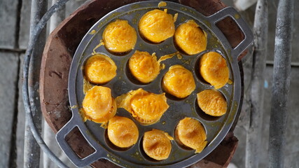 Traditional Thai street dessert (Khanom Krok). Street vendor made coconut rice pancake.