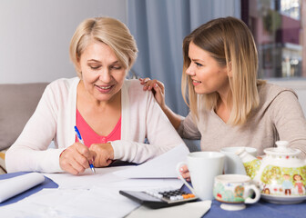 Adult daughter helps her mother to lead home accounting