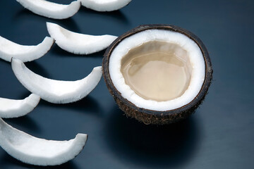 Fototapeta na wymiar pieces of chopped coconut on a dark background. vitamin fruits. healthy food