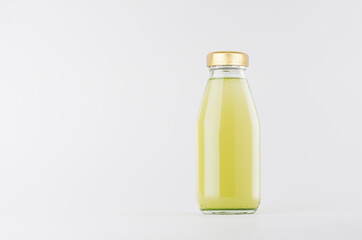 Green fruit juice in glass bottle with gold cap  mock up on white background with copy space, template for packaging, advertising, design product, branding.