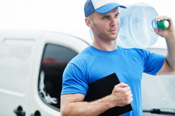 Delivery man with clipboard in front cargo van delivering bottles of water.