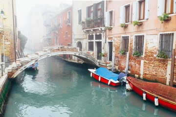 Venice Italy. Beautiful postcard of Venice architecture and its canals. Old brick house and bridge on a foggy day.