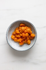 freshly picked cloudberries in rustic plate on white marble background with copy space