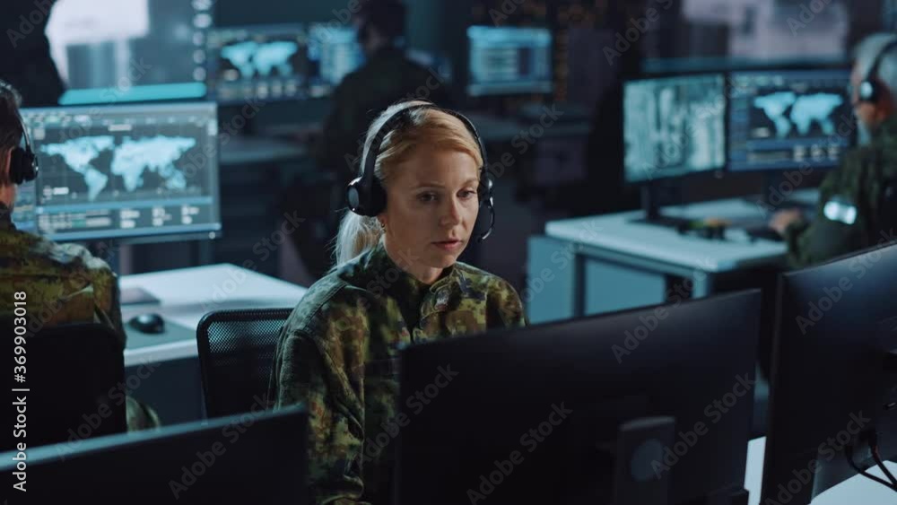 Poster female military surveillance officer talking on headset in central office hub for cyber operations, 