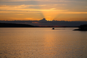 The sun setting in the clouds. The sunset on the lake Vesij&auml;rvi. Lahti. Finland.