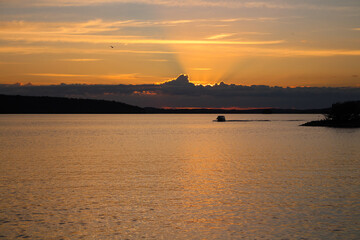 The sun setting in the clouds. The sunset on the lake Vesijärvi. Lahti. Finland.