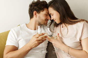 Young couple drinking white wine and relaxing at home