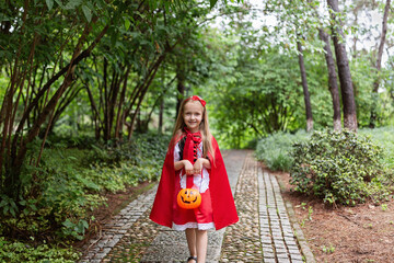 Little Girl in costume of red hat in the park. Happy Halloween concept