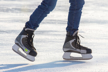 Legs of a skater on ice skating on the street ice rink. winter sport. hobbies and active recreation in sports. © photosaint