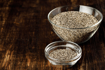 Glass bowl with chia seeds on wooden table