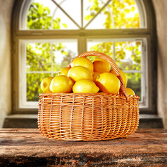 Fresh lemons fruits in basket and blurred window background 