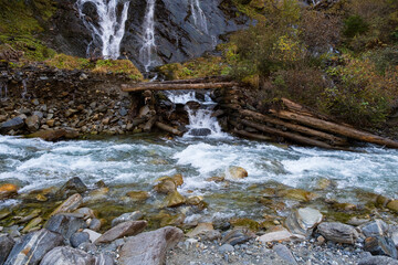 ein rauschender Gebirgsbach mit einem Wasserfall