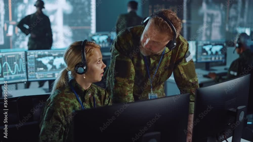 Leinwandbilder military surveillance officers talking next to a computer screen in central office for cyber operati