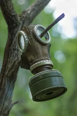Fotobehang Oud verlaten gasmasker hangend aan een tak © Albert Ziganshin