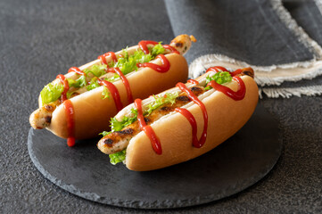 Two hot dogs on stone board