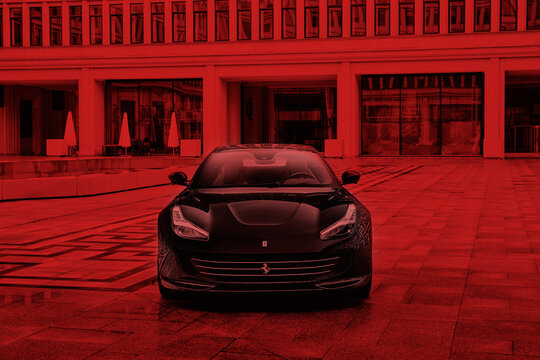 Warsaw / Poland - 01/01/2018: Ferrari In The Courtyard Of The Socialist Realist Building Where Once Was The Seat Of The Socialist Party, And Today Is The Stock Exchange. Monochromatic Picture In Red