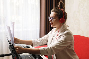 Young  woman playing synthesizer at home