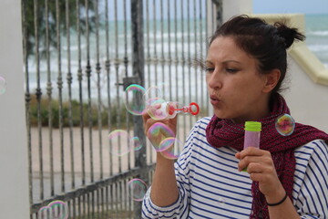 Giovane donna che gioca con le bolle di sapone - divertimento